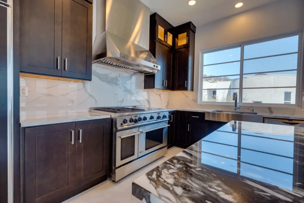 Modern kitchen with dark cabinets and stainless steel appliances.