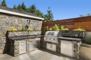 An outdoor kitchen with a built-in grill and sink.