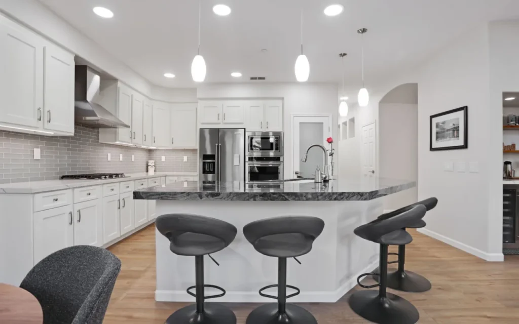 A modern kitchen with a large island and stainless steel appliances.