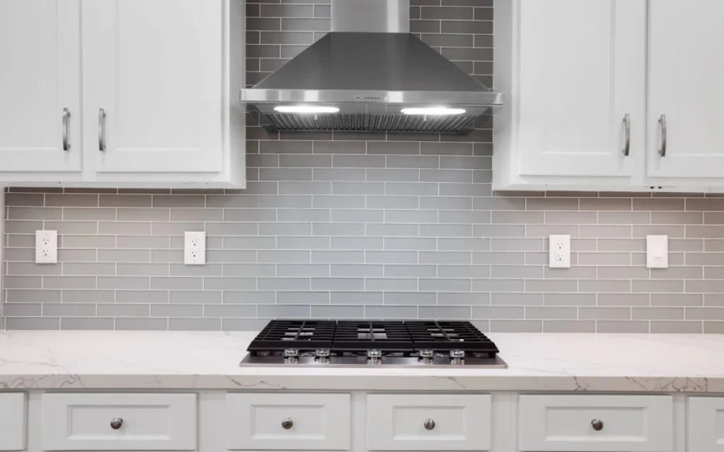 A stainless steel range hood over a stovetop.