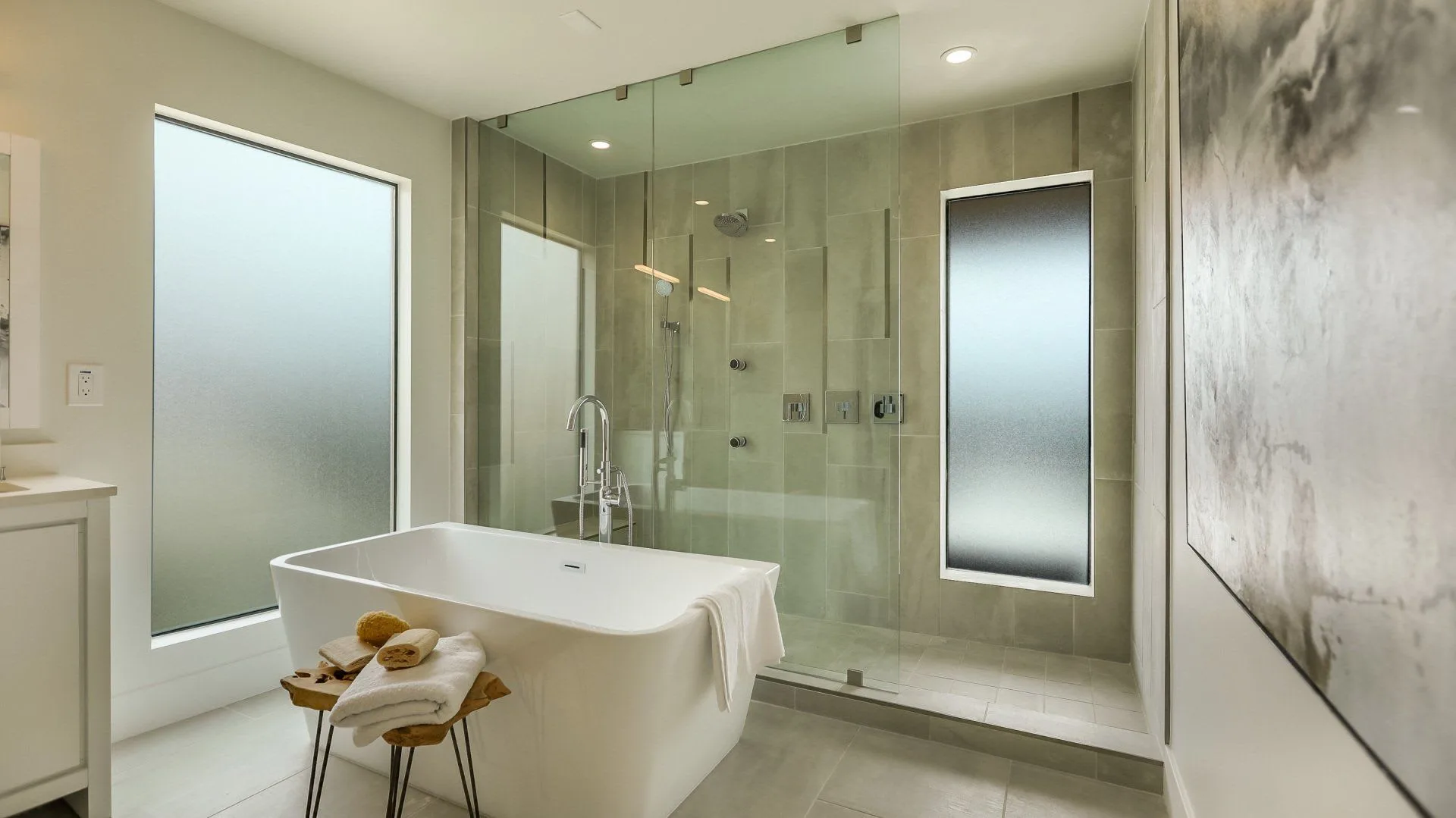 Modern bathroom with bathtub and glass shower enclosure.