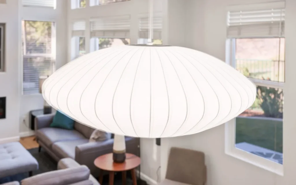 White oval-shaped hanging lamp in living room.