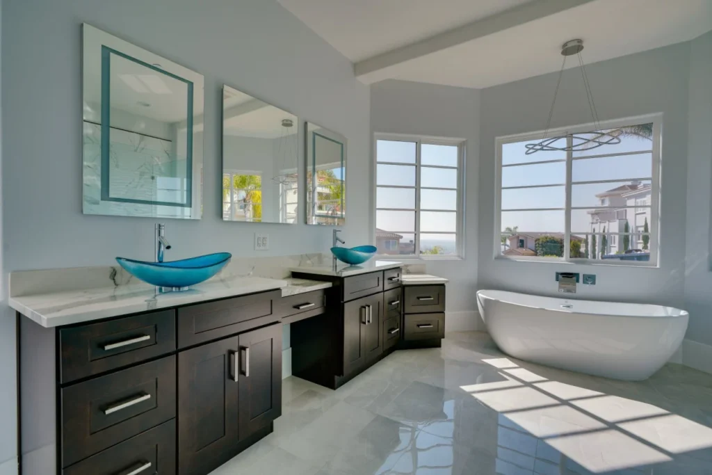 Modern bathroom with large windows and a freestanding tub.