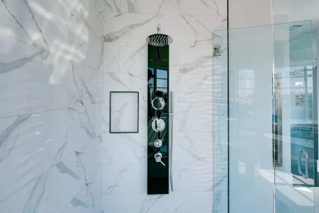 Black shower panel with marble tiles.