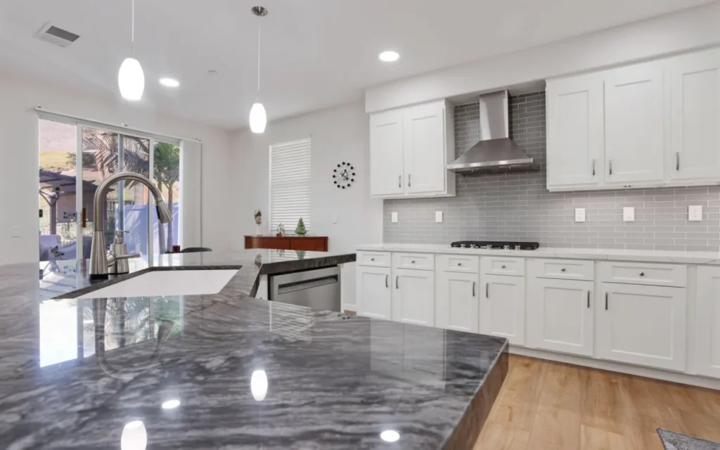 Modern kitchen with white cabinets and stainless steel appliances.
