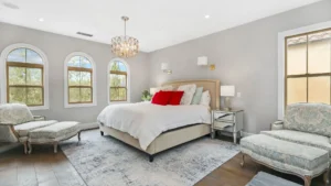 Elegant bedroom with two windows and a pair of armchairs.