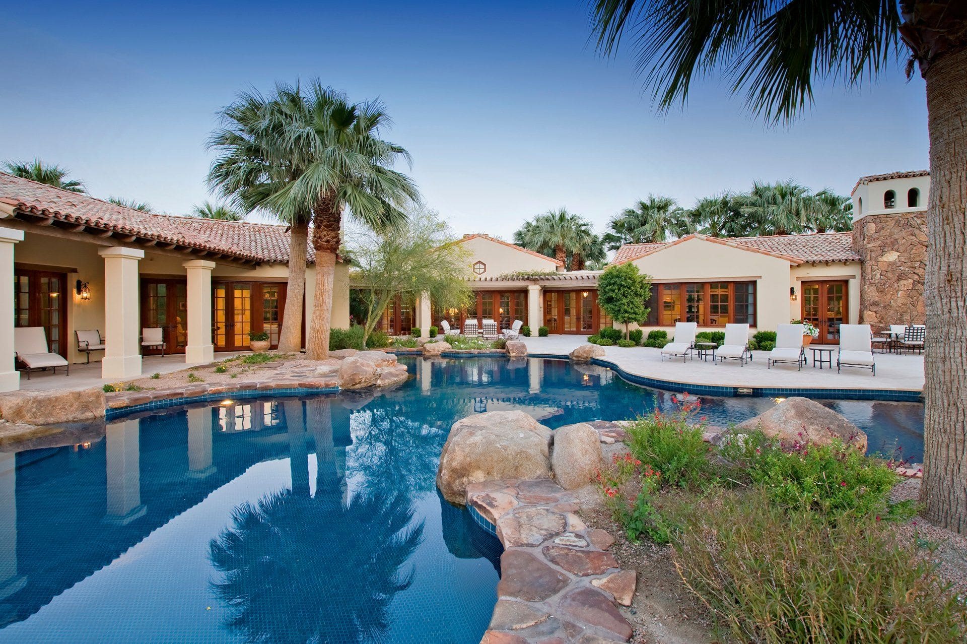 Palm trees and a swimming pool in a backyard.
