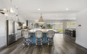 A kitchen island with blue chairs and a large white lamp.