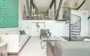 A living room with a spiral staircase and a green wall.