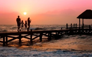 Family silhouette on a dock at sunset.