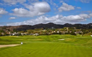 Golf course with green hills and blue sky