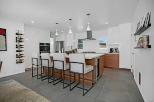 Modern kitchen with island and wine rack.