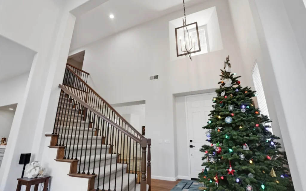 Staircase and Christmas tree in a two-story foyer.