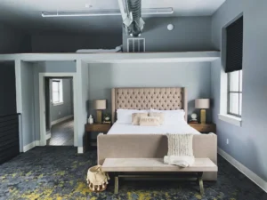 Bedroom with gray walls and a gray patterned carpet.