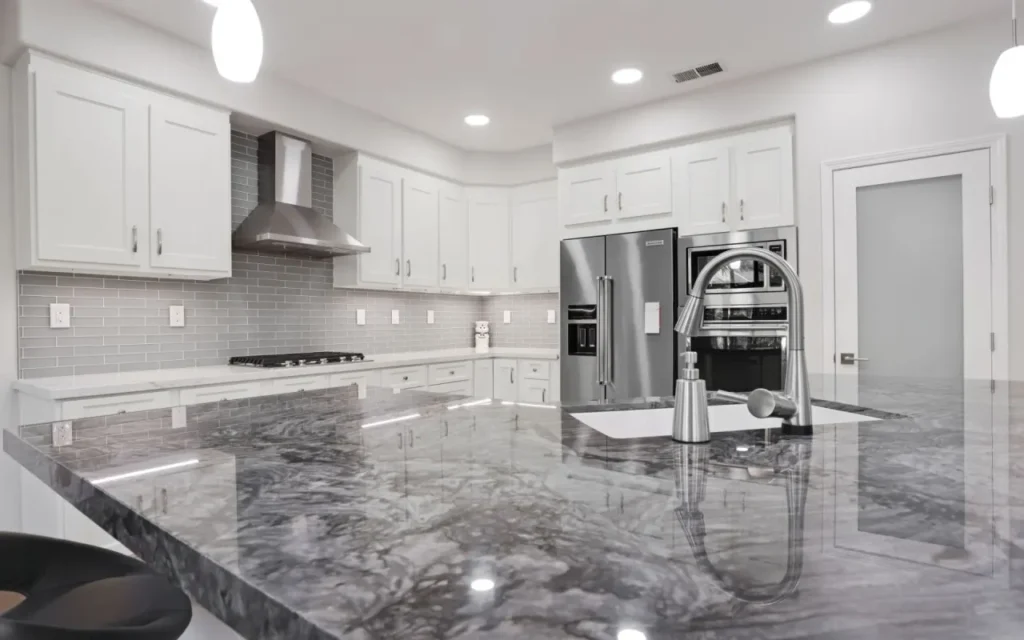 Large kitchen island with grey marble top.