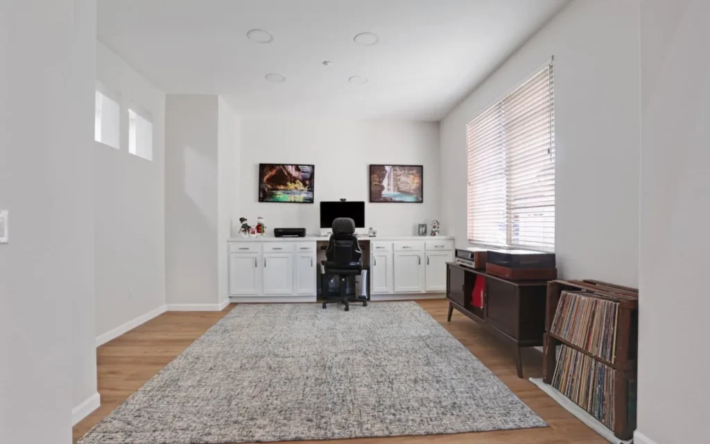 Home office with waterfall pictures and gray rug.