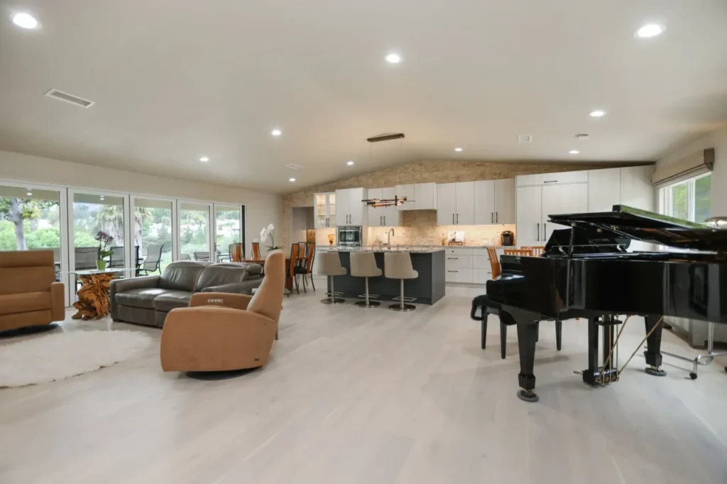 Piano in middle of living room and kitchen.
