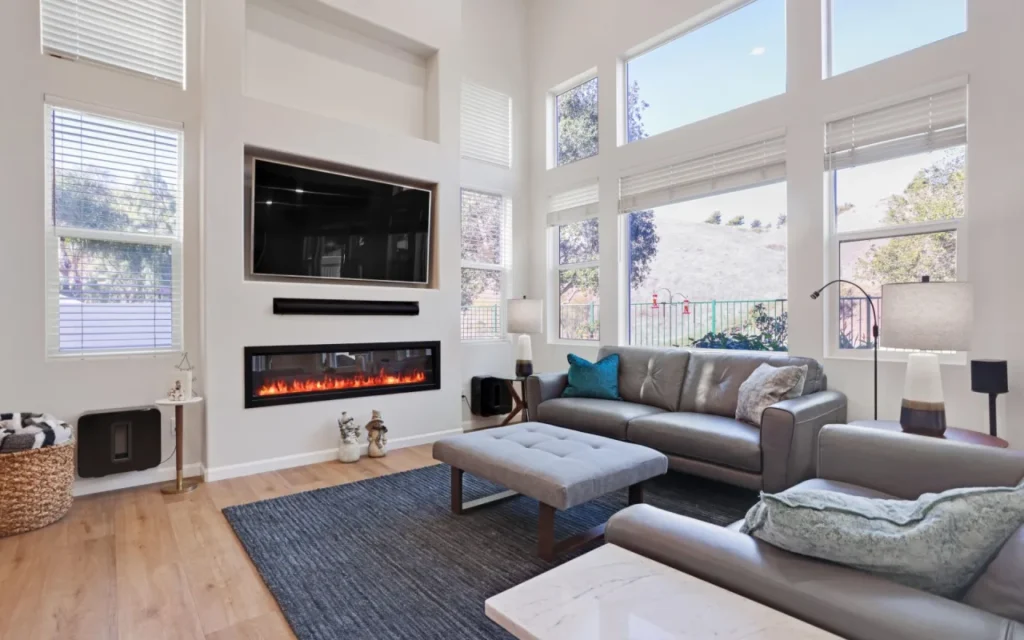 Bright living room with fireplace and large windows.