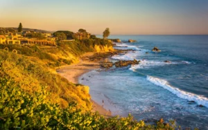 Rocky beach with large waves at sunset.