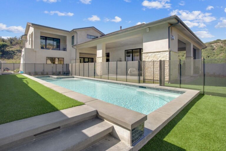 Backyard with pool and artificial grass.