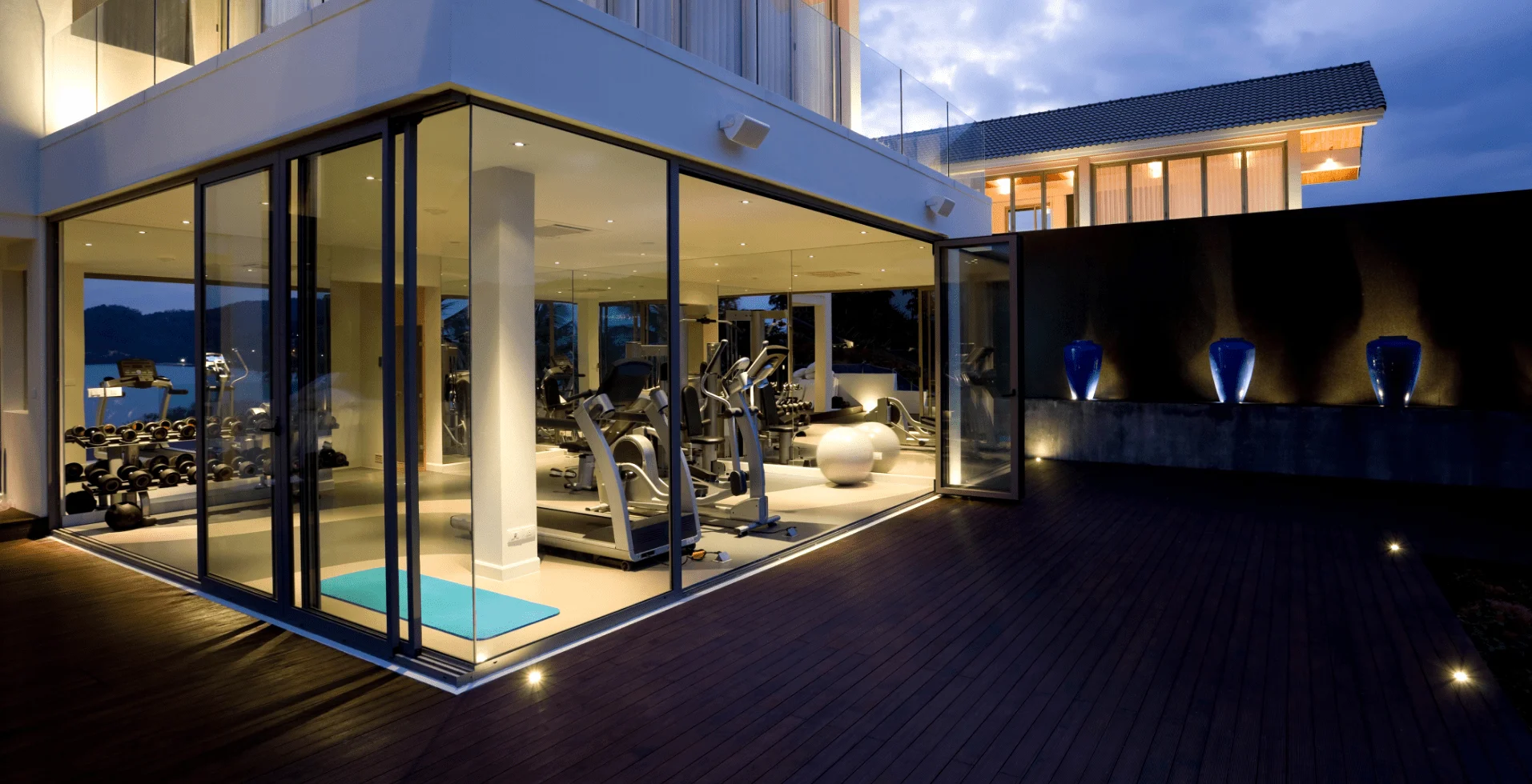 A home gym with a view of the pool.