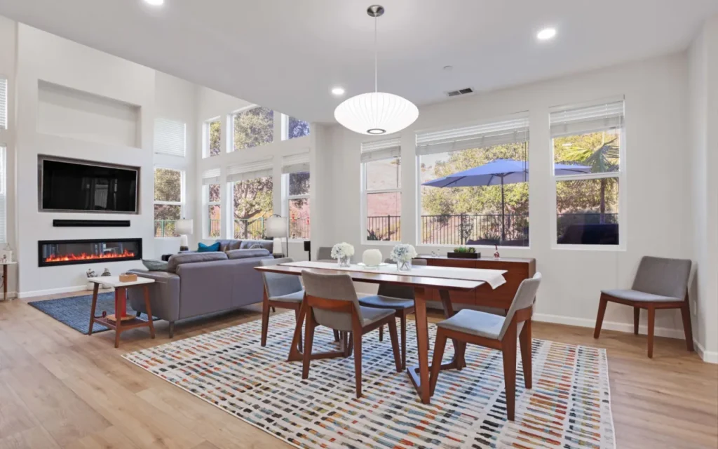 An open living and dining room with a fireplace and large windows.