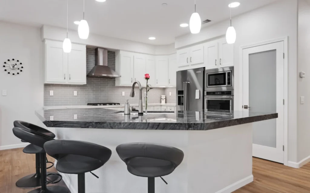 Modern kitchen with island and stainless steel appliances.