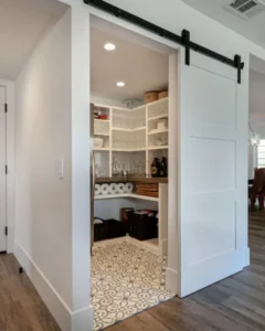 Pantry with white shelves and patterned floor tiles.