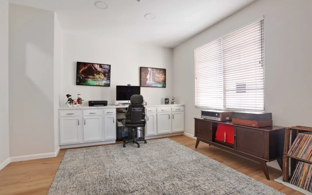Home office with desk, computer, and record player.