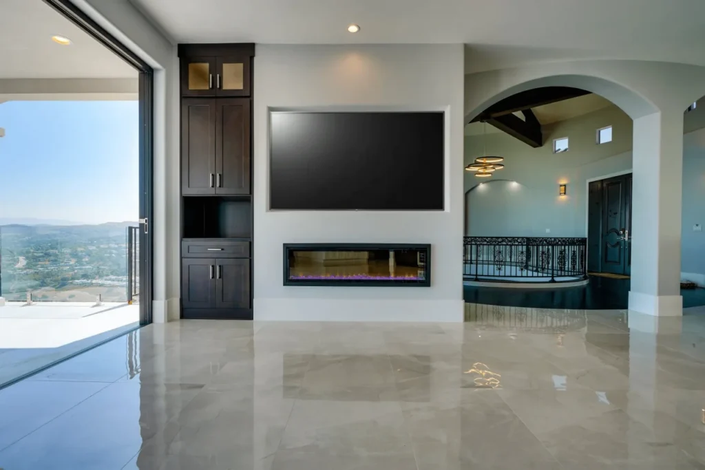Modern living room with fireplace and large windows.