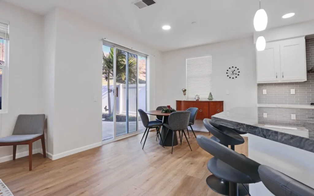 Dining area with table, chairs, and sliding glass door.