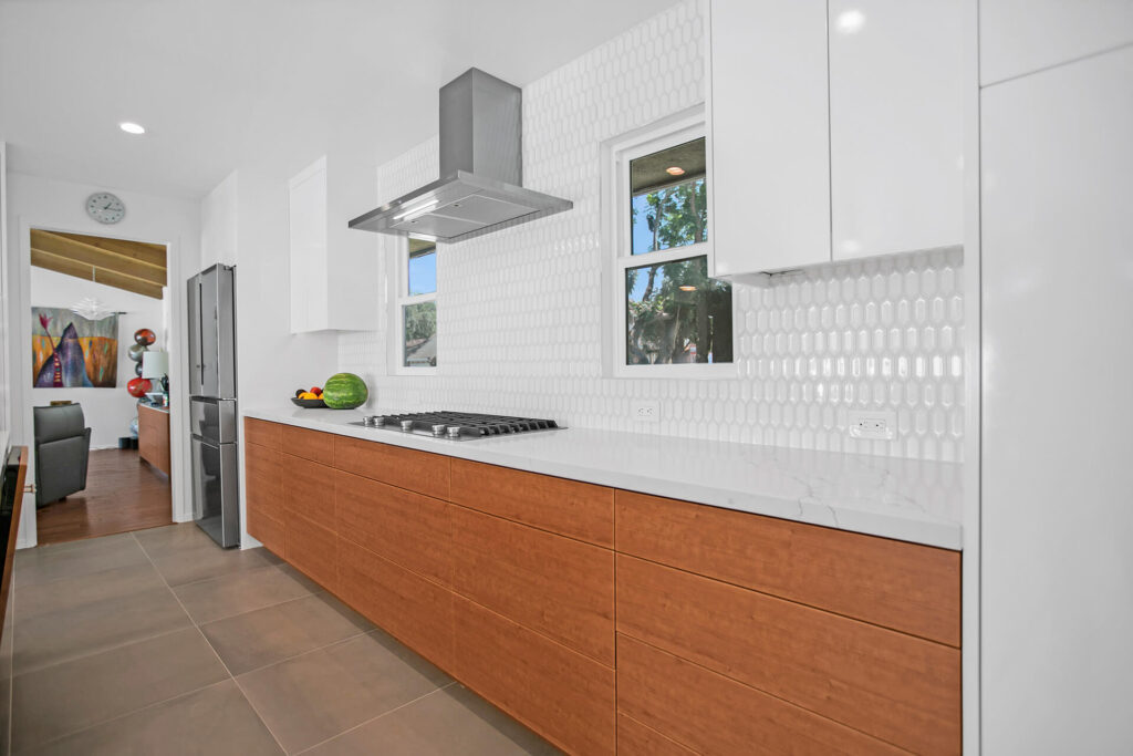 Renovated kitchen with white cabinets and wood grain island
