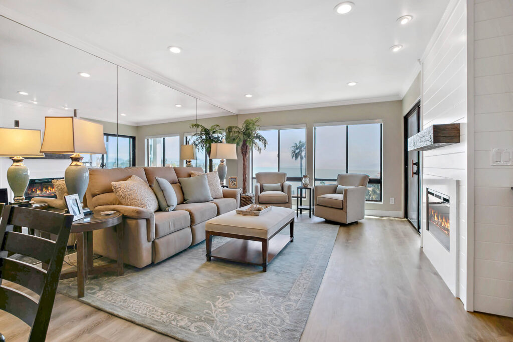 Living room with sofa, rug, coffee table, two armchairs, and fireplace.
