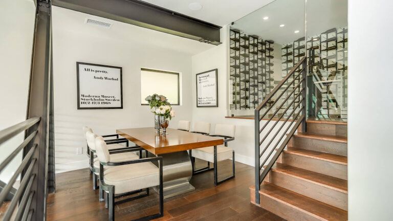 Black and white photo of a dining room with a wine rack.