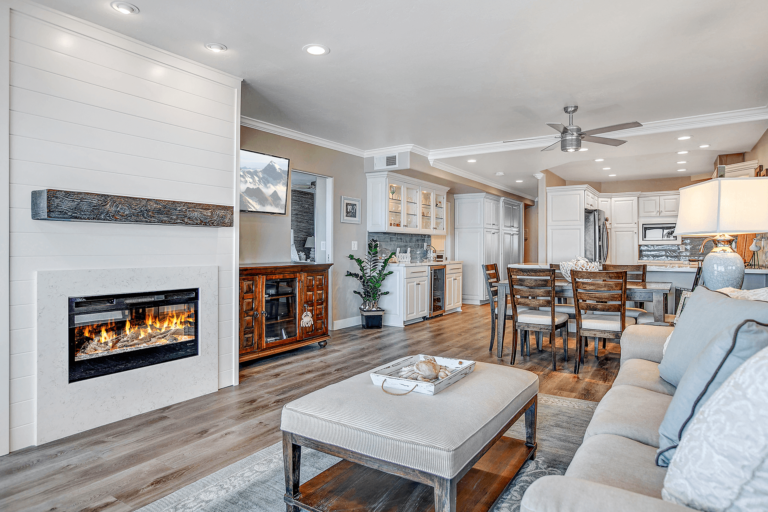 Living room with fireplace, TV, sofa, rug and coffee table.