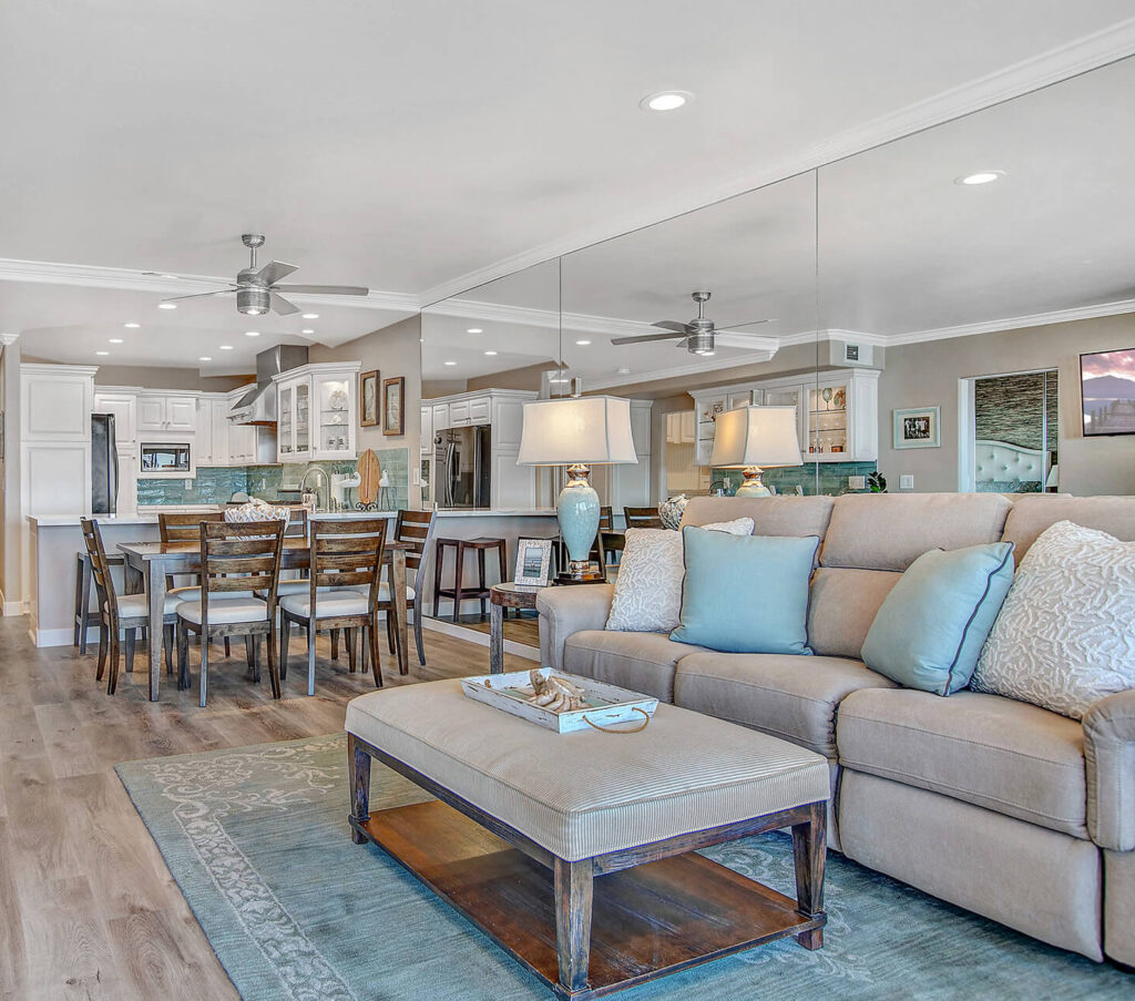 Living room with sofa, coffee table, rug, and dining table in the background.