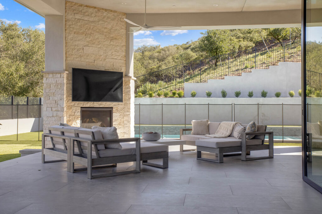 Outdoor living space with fireplace and pool.