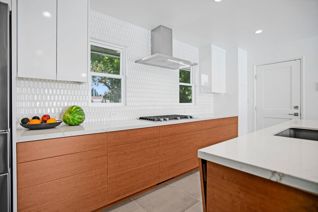 Modern kitchen with white cabinets and wood grain island.