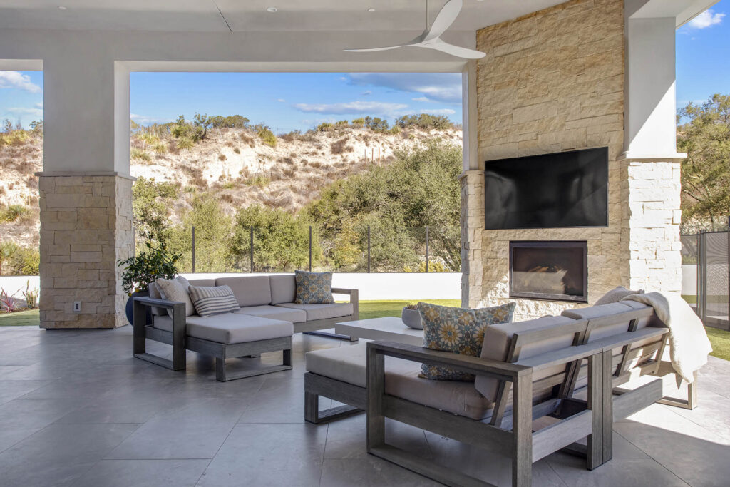 Outdoor living space with sofas and TV.