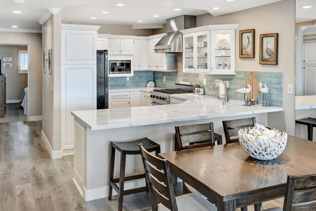 White kitchen with stainless steel appliances and breakfast bar.