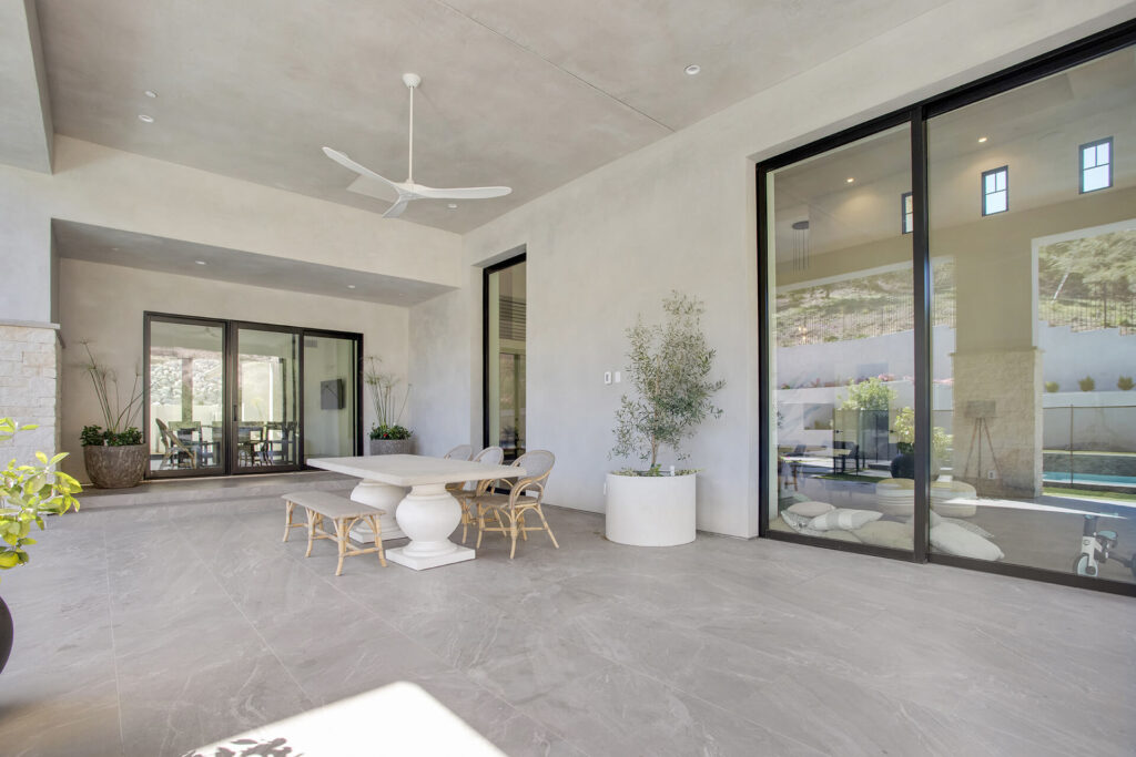 Outdoor patio with table, chairs, and potted plants.