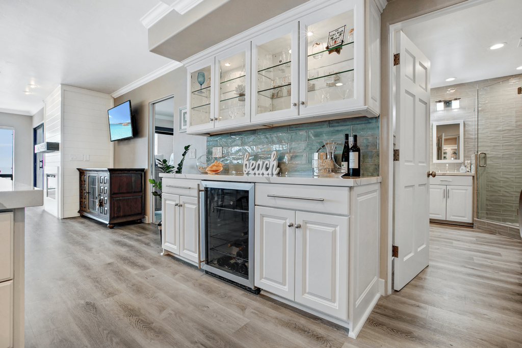 White cabinets with wine rack and beach sign.