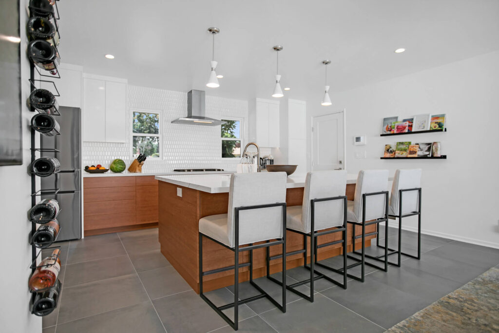 Modern kitchen with island and wine rack.