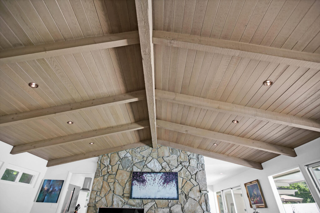 A wooden ceiling with a stone fireplace.