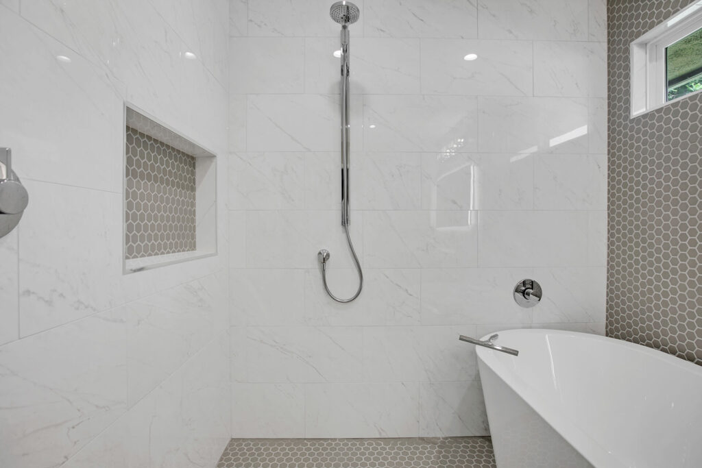 Modern bathroom with marble tiles and bathtub.