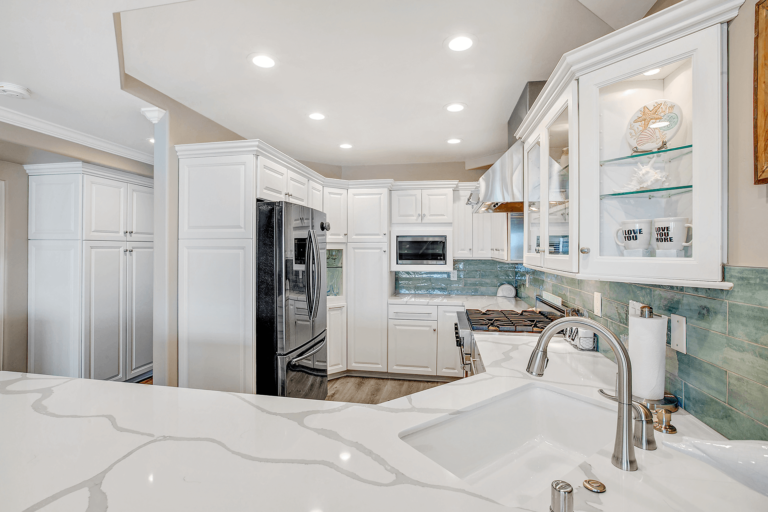 White kitchen with stainless steel appliances and quartz countertops