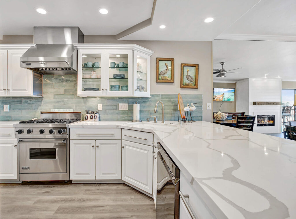 White kitchen with stainless steel appliances and quartz countertops.