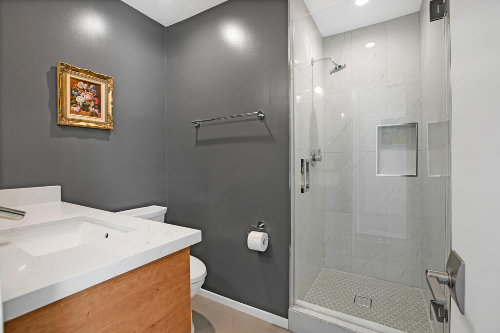 Modern bathroom with dark walls and white marble shower.
