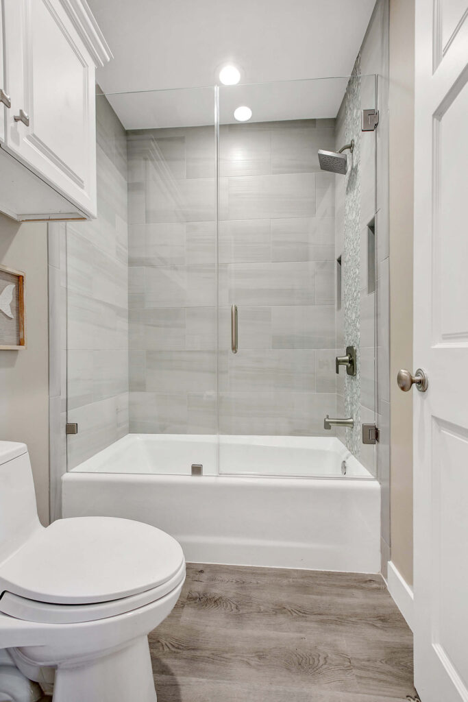 Modern bathroom with gray tile and glass shower door.