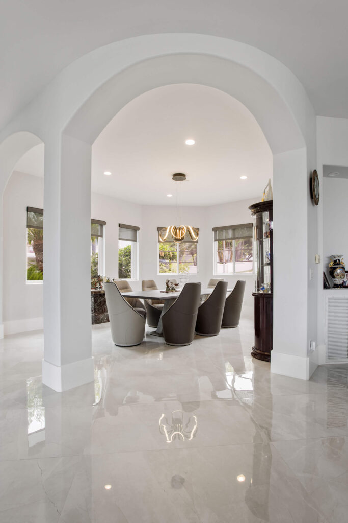 Elegant dining room with marble floor and large windows.